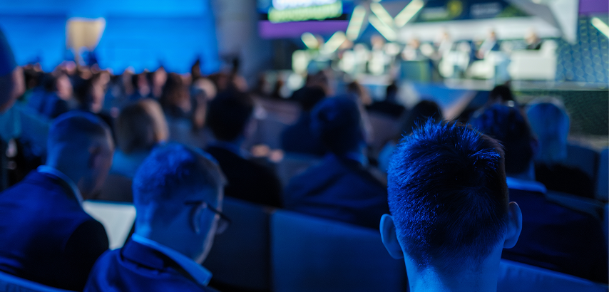 A crowd of people attending a conference